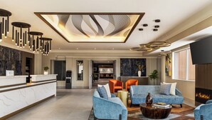 Amplia sala de estar con un mostrador de recepción de mármol, iluminación moderna y una chimenea.