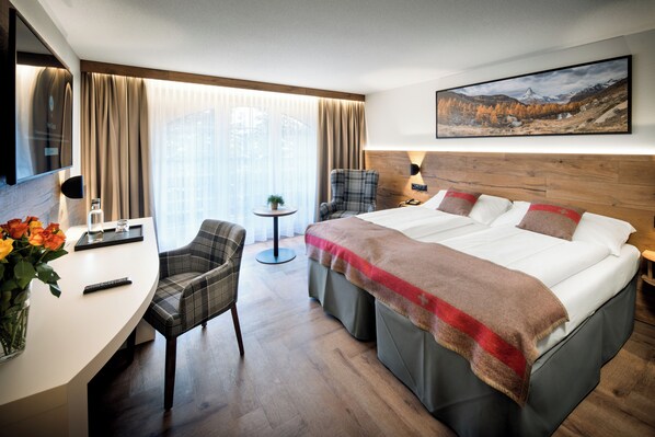 أغطية فراش متميزة وخزنة داخل الغرفة ومكتب وستائر تعتيم