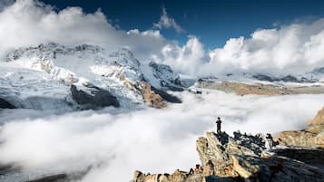 Un paysage montagneux caractérisé par un terrain rocheux et des sommets enneigés.