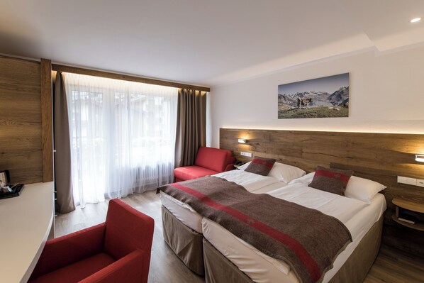 أغطية فراش متميزة وخزنة داخل الغرفة ومكتب وستائر تعتيم