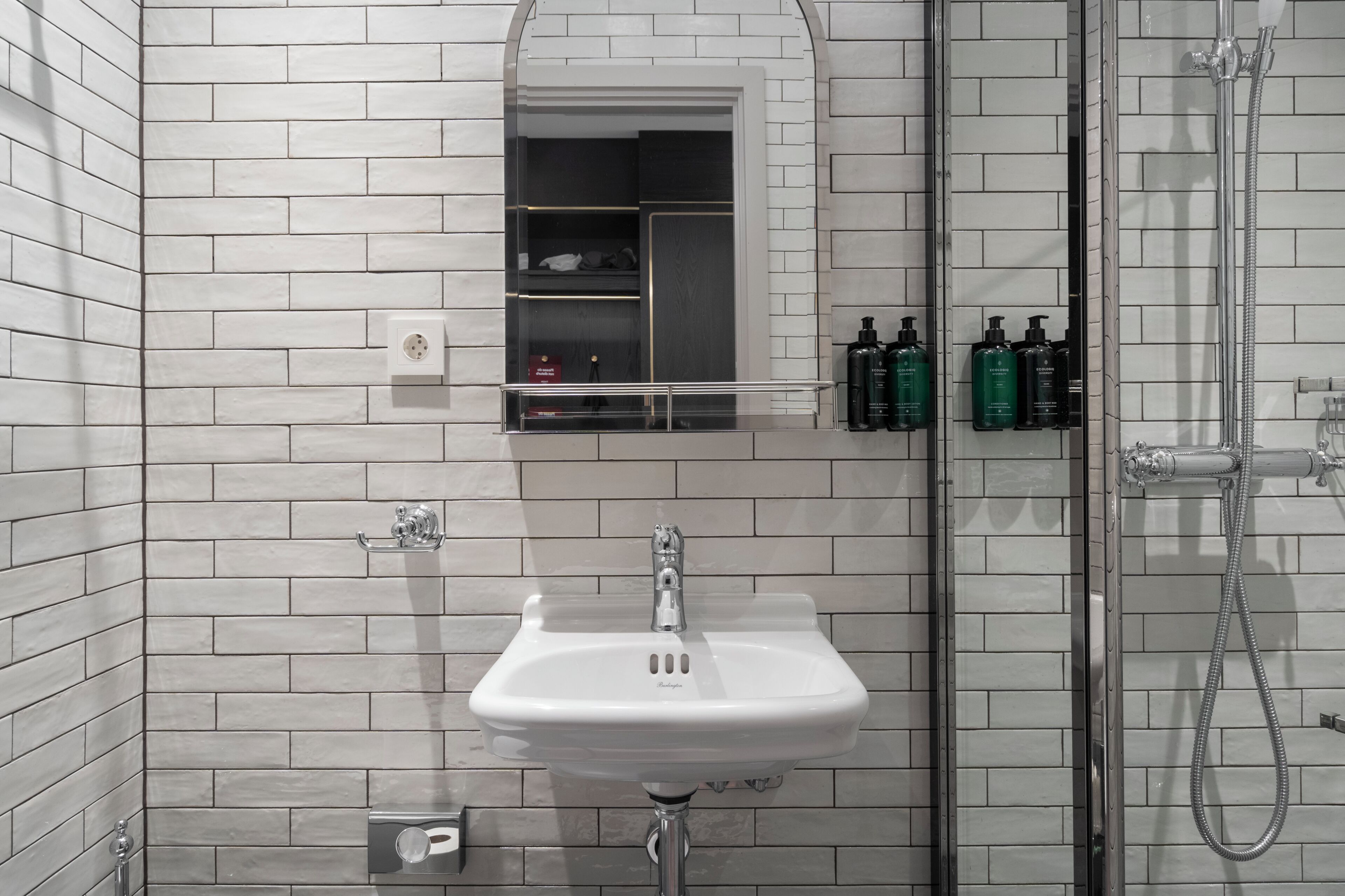 A bathroom with a white sink, a mirror, and a shower.