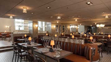 En restaurang med avskilda bås, bord och en bardisk.