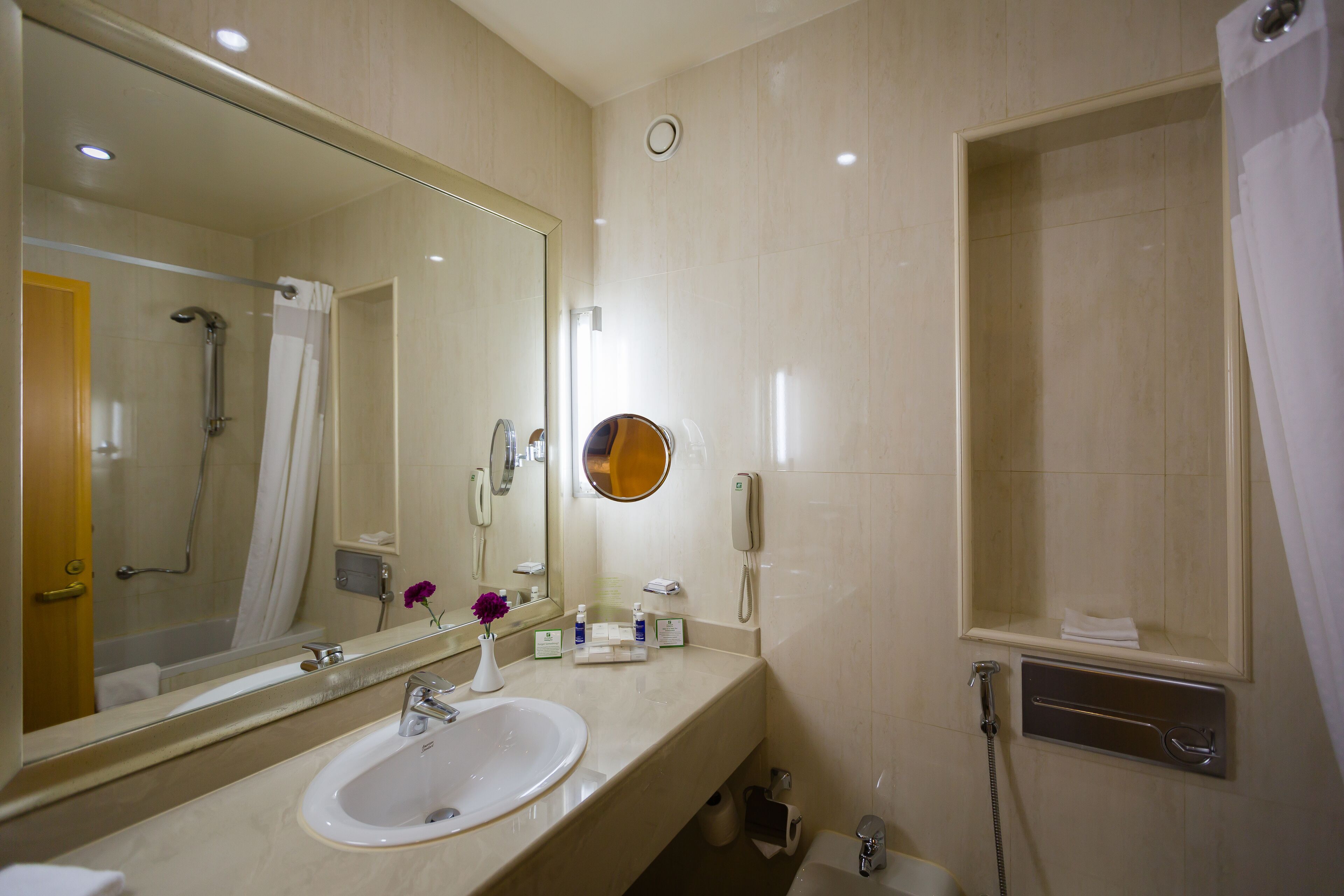 A bathroom with a sink, mirror, and shower.