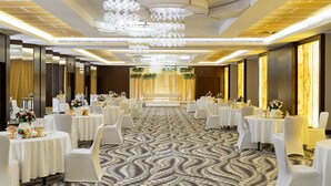 A banquet hall with round tables, white chairs, and a patterned carpet. - Holiday Inn Yanbu by IHG (Yanbu)