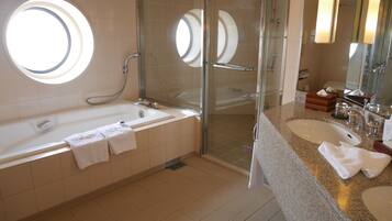 A modern bathroom with a bathtub, a glass-enclosed shower, and a vanity with a sink and mirror.