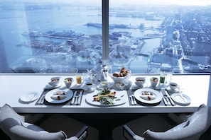 A dining table set for two with a city view, including a bridge and port. - Yokohama Royal Park (Yokohama)
