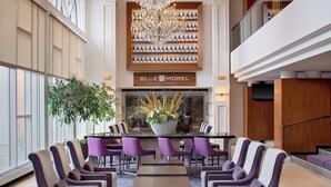 A modern hotel lobby with a reception desk, purple chairs, a chandelier, and a large window. - The Westin Governor Morris, Morristown (Morristown)