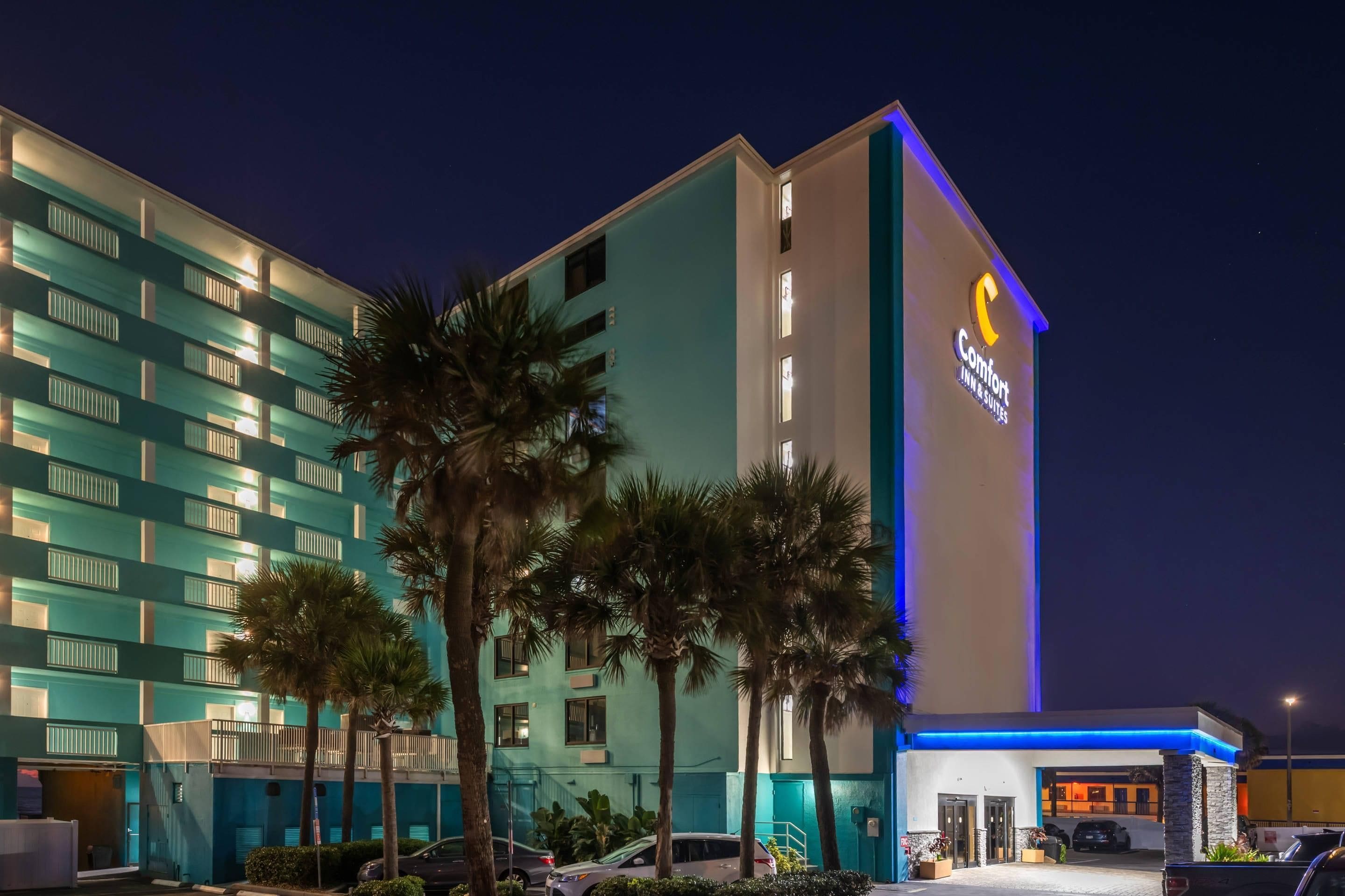 A hotel with a prominent 'Comfort Inn & Suites' sign, multiple floors, and a parking area.