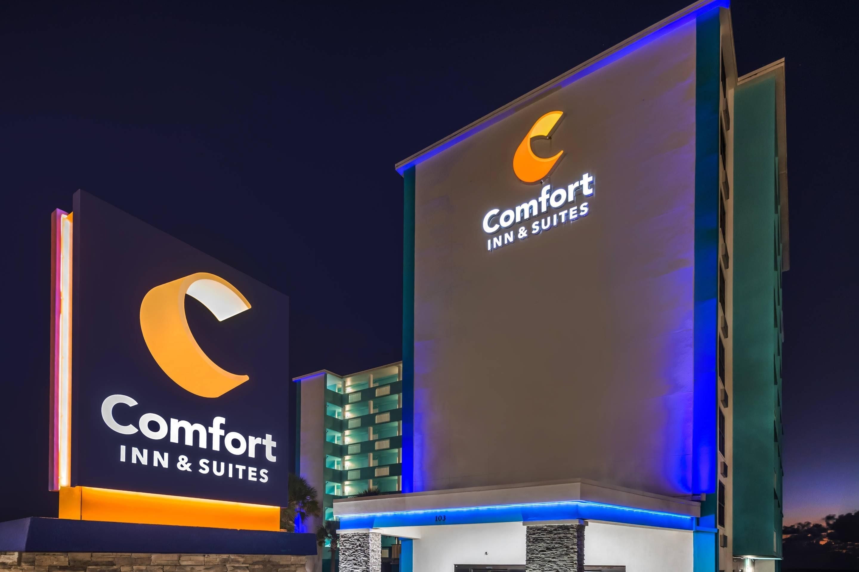 Un hotel Comfort Inn & Suites con letreros iluminados y una fachada moderna.