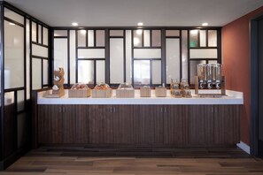 A modern kitchen with a wooden countertop, cabinets, and a built-in refrigerator.