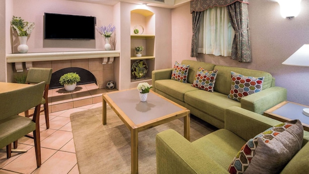 Una sala de estar con sofá, mesa de centro, televisor, chimenea y plantas decorativas.