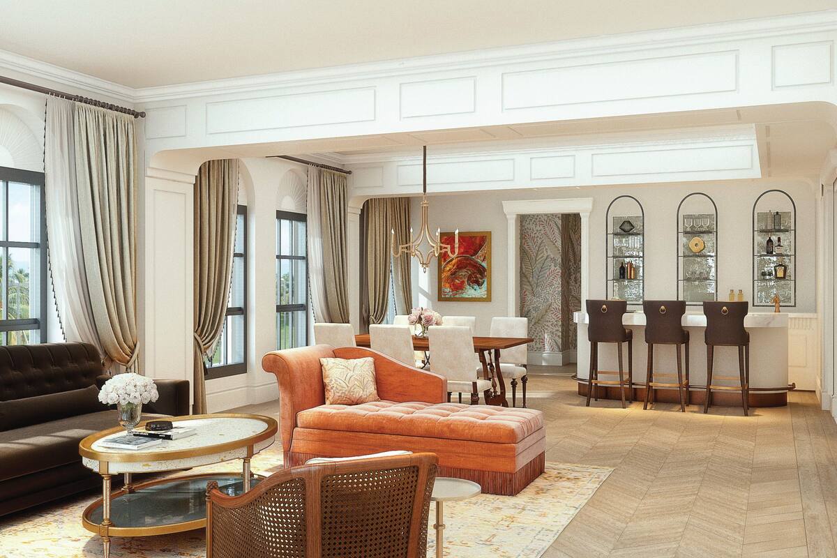 A spacious living room with a sofa, armchair, and ottoman, a dining area with chairs and a table, and a bar area with stools.