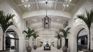 A grand lobby with high ceilings, large chandeliers, and symmetrical archways.