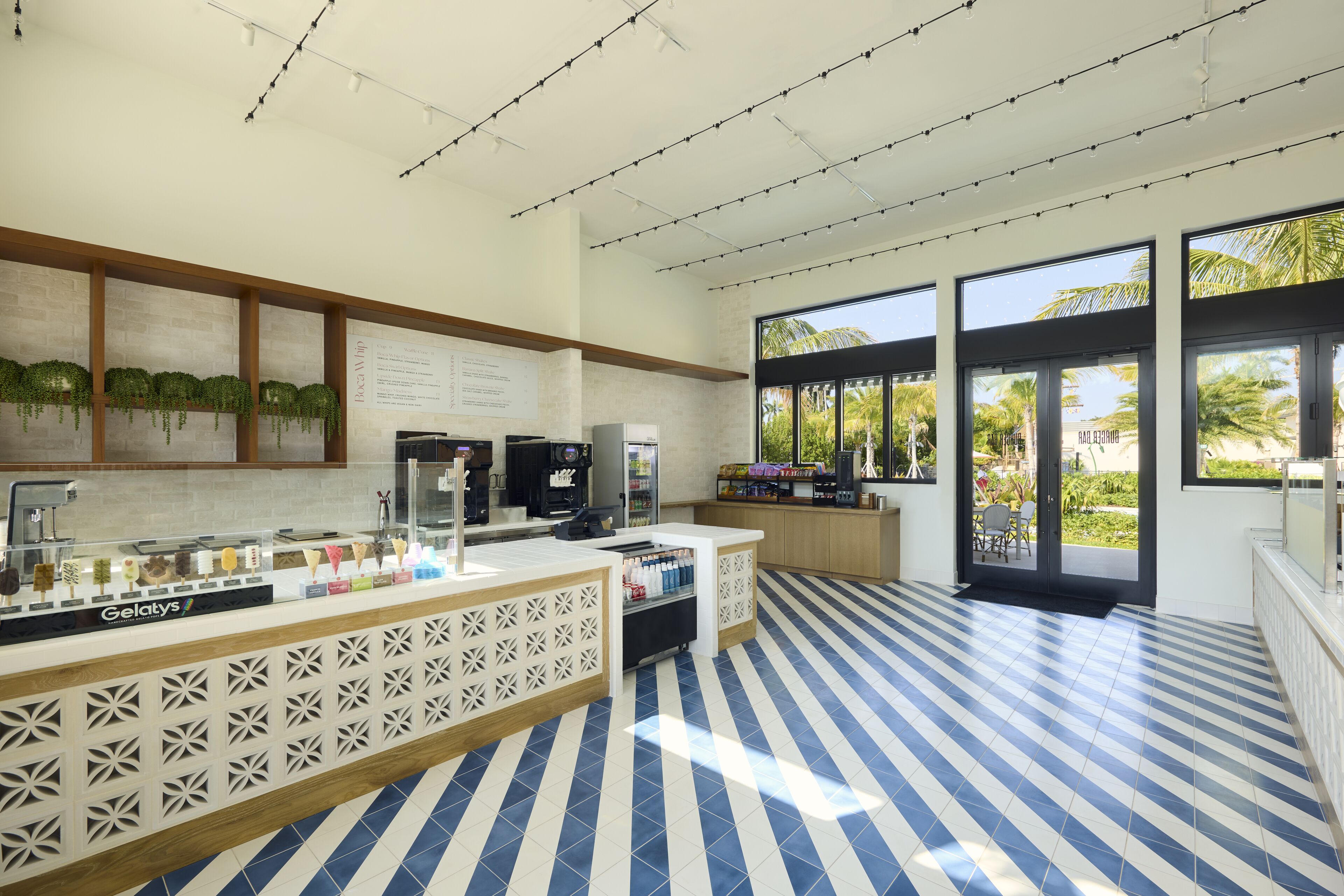 A modern kitchen area with a counter displaying various food items, a coffee machine, and a refrigerator.