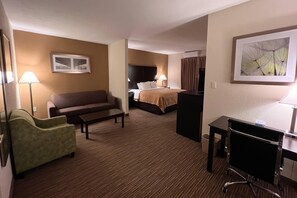 A hotel room with a sofa, a desk, a bed, and a chair. - Quality Inn & Suites Paragould (Paragould)