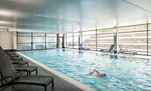 An indoor swimming pool with clear water, lounge chairs, and large windows. - Norton House Hotel & Spa (Newbridge)