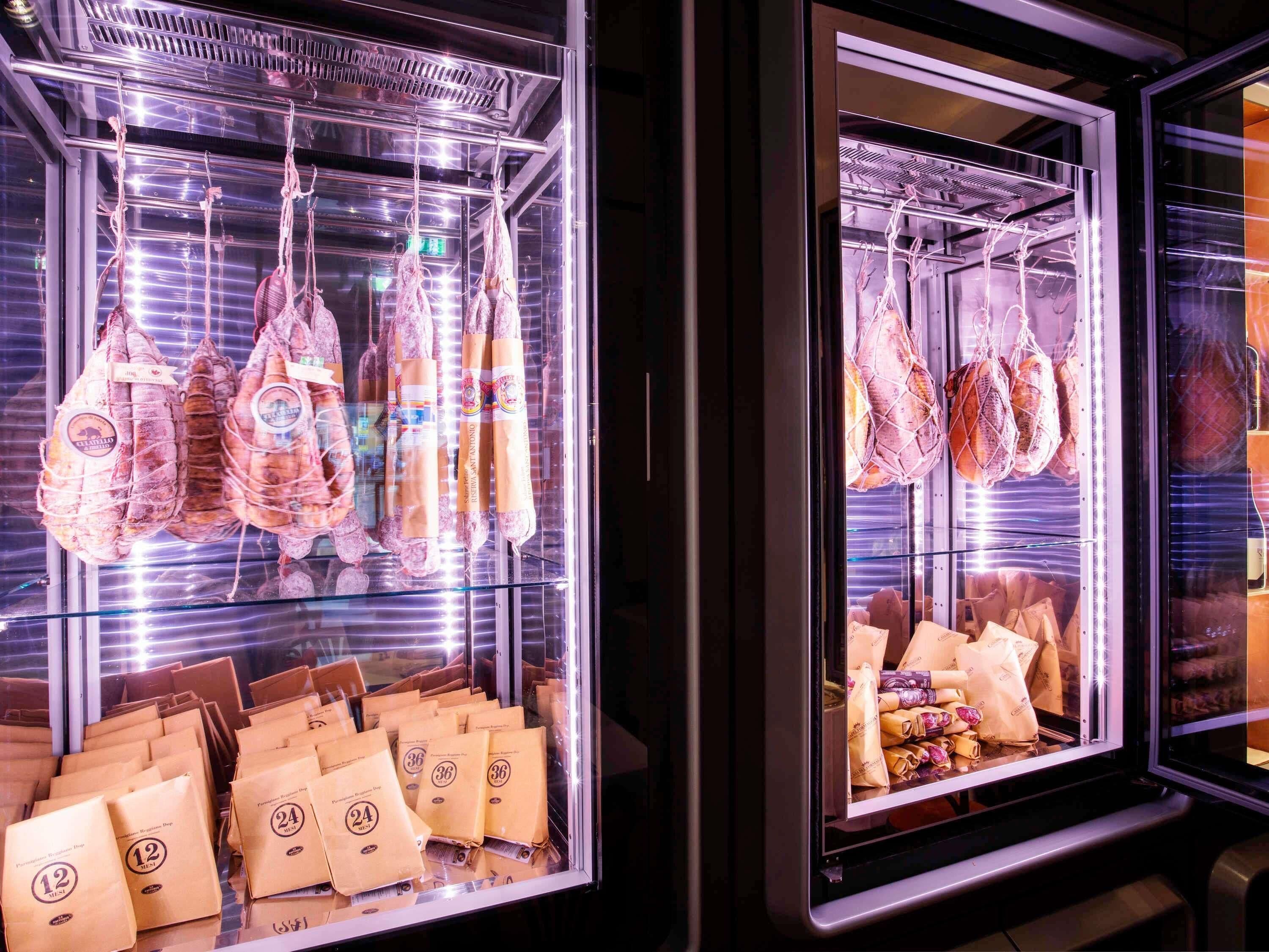 Refrigerated display cases with packaged meats and bags of goods.
