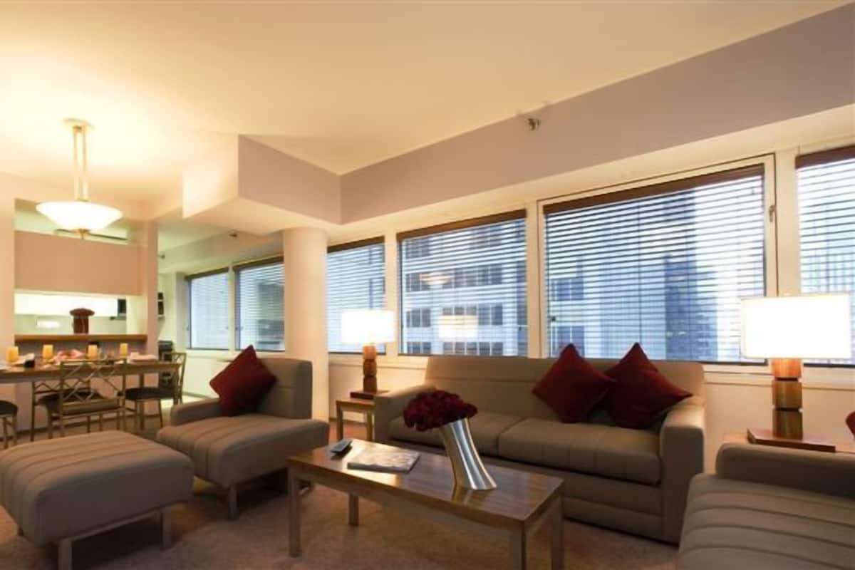 Un salon comprenant un canapé, des fauteuils, une table basse et un coin repas avec une table et des chaises.