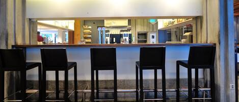 A bar area with four black bar stools and a counter.