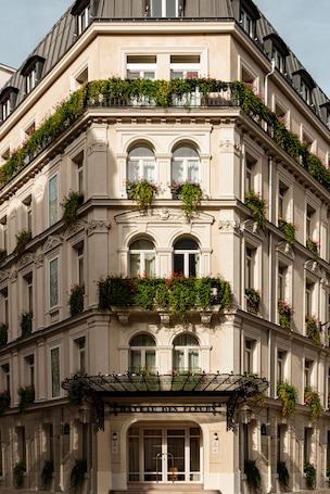 A multi-story building with balconies adorned with plants and flowers.
