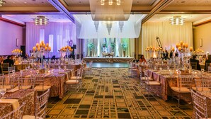 A banquet hall with tables set for a formal event, featuring a stage at the front with curtains and a chandelier. - DoubleTree by Hilton Omaha Downtown (Omaha)