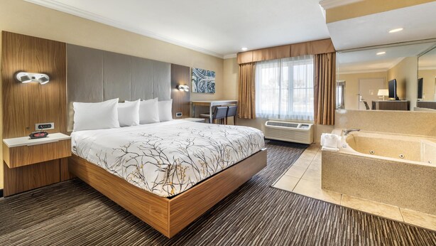 A modern hotel room with a large bed, a desk, a bathroom with a bathtub, and a large mirror. - Best Western Airpark Hotel - LAX Airport LA  Stadium (Inglewood)