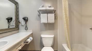 A bathroom with a toilet, a sink, a mirror, a towel rack, and a shower curtain.
