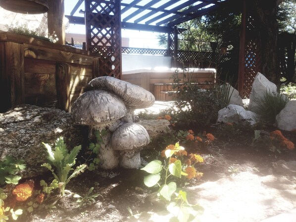 Un jardín con rocas grandes, una estructura de madera y una pérgola.