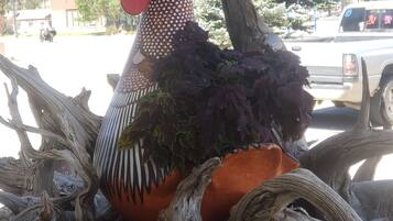 A decorative rooster sculpture surrounded by twisted tree branches.