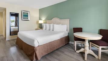 Une chambre d’hôtel avec un grand lit, une table ronde et une chaise.