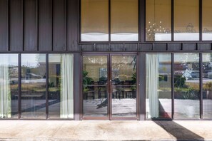 A building with large glass doors and windows, reflecting outdoor scenery. - Days Inn by Wyndham Florence/I-95 North (Florence)