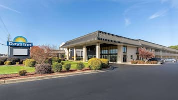 A Days Inn hotel with a modern design, featuring a large sign, a covered entrance, and well-maintained landscaping.