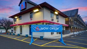 A motel with a '6' sign, a 'NOW OPEN' banner, and a parking lot. - Motel 6 Carlisle, PA - Cumberland Valley (Carlisle)