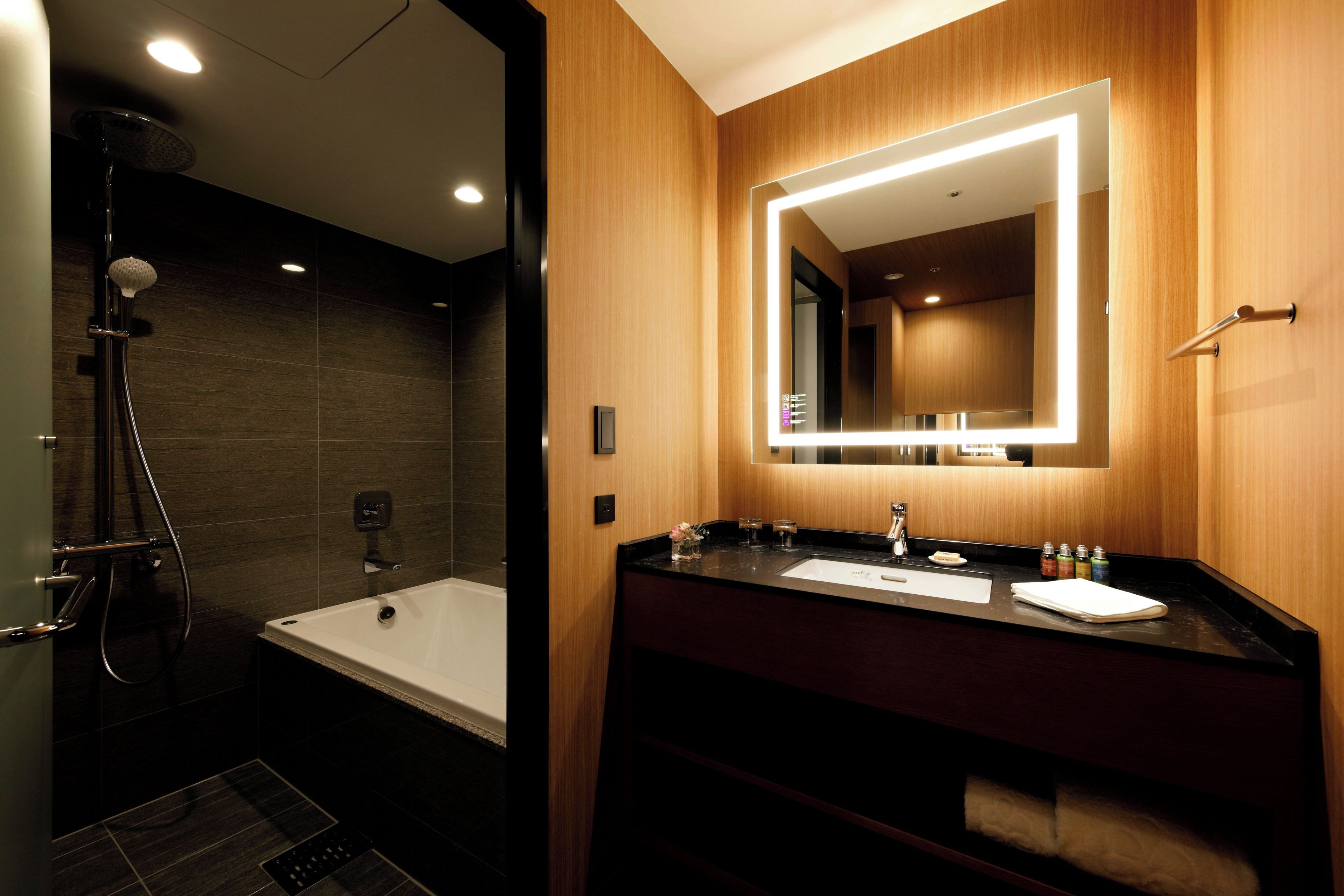A modern bathroom with a bathtub, a shower, and a vanity with a mirror.