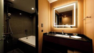 A modern bathroom with a bathtub, a shower, and a vanity with a mirror.