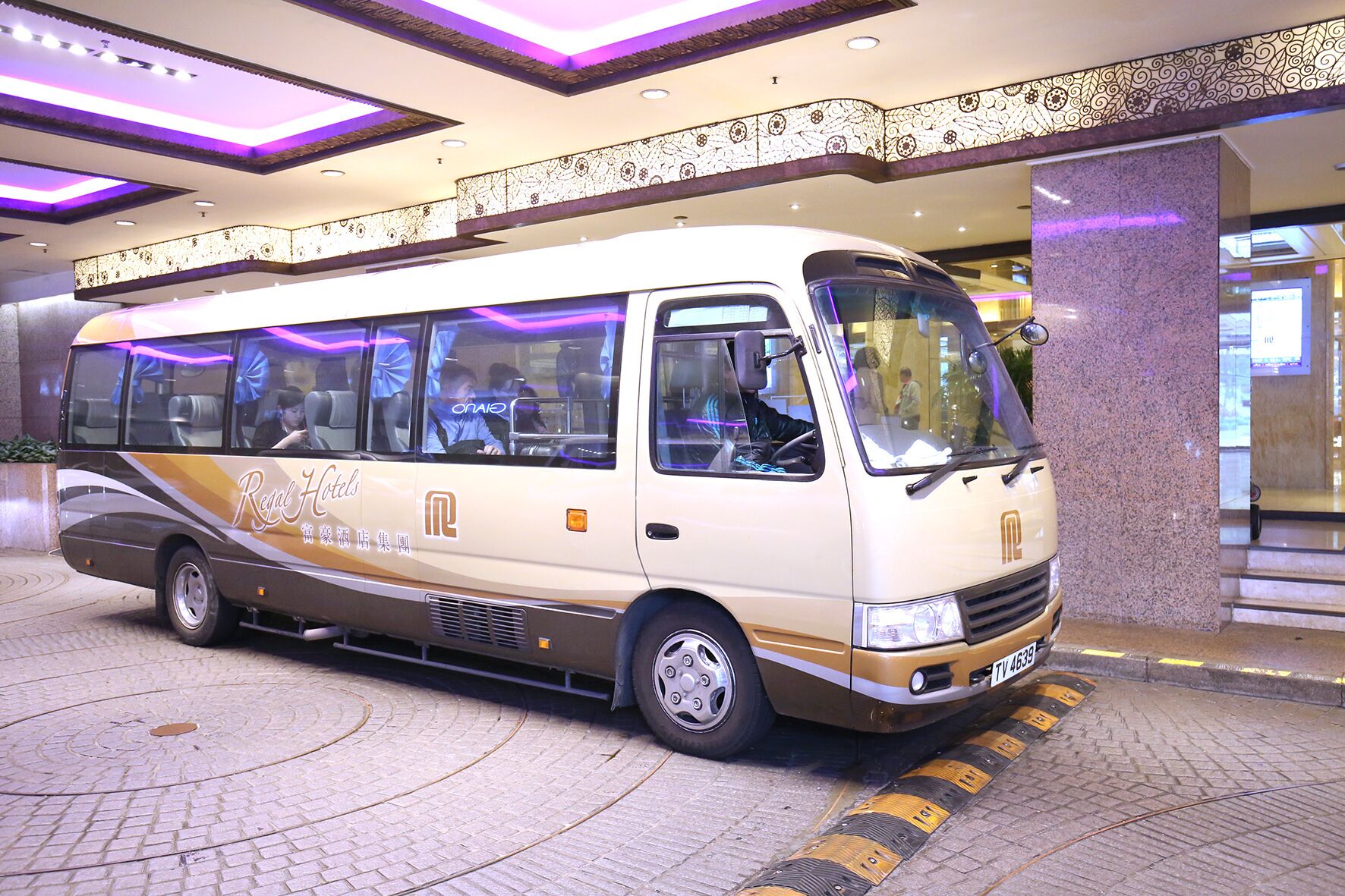 A white van with the text "Regal Hotels" parked inside a building.