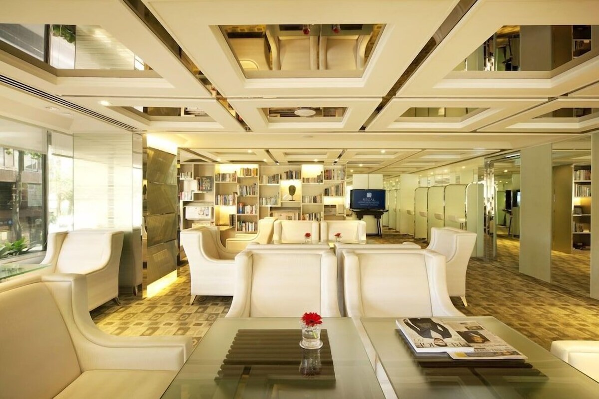 A modern interior with a central seating area, a piano, and a television.