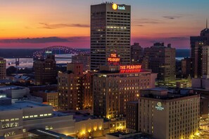 A hotel with a prominent 'The Peabody' sign, surrounded by other buildings and a bridge in the background. - The Peabody Memphis (Memphis)