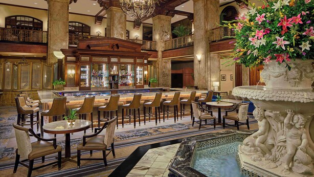A spacious lobby with a bar area, multiple seating arrangements, and a decorative fountain. - The Peabody Memphis (Memphis)
