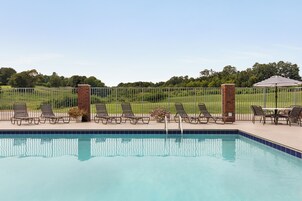 Una piscina al aire libre de temporada, sombrillas