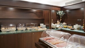 Un área de bufé con diferentes alimentos y un jarrón decorativo.
