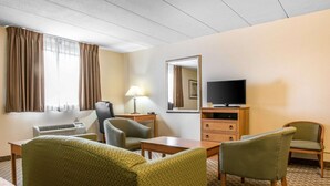 A hotel room with a bed, a desk, a chair, a television, and a mirror.