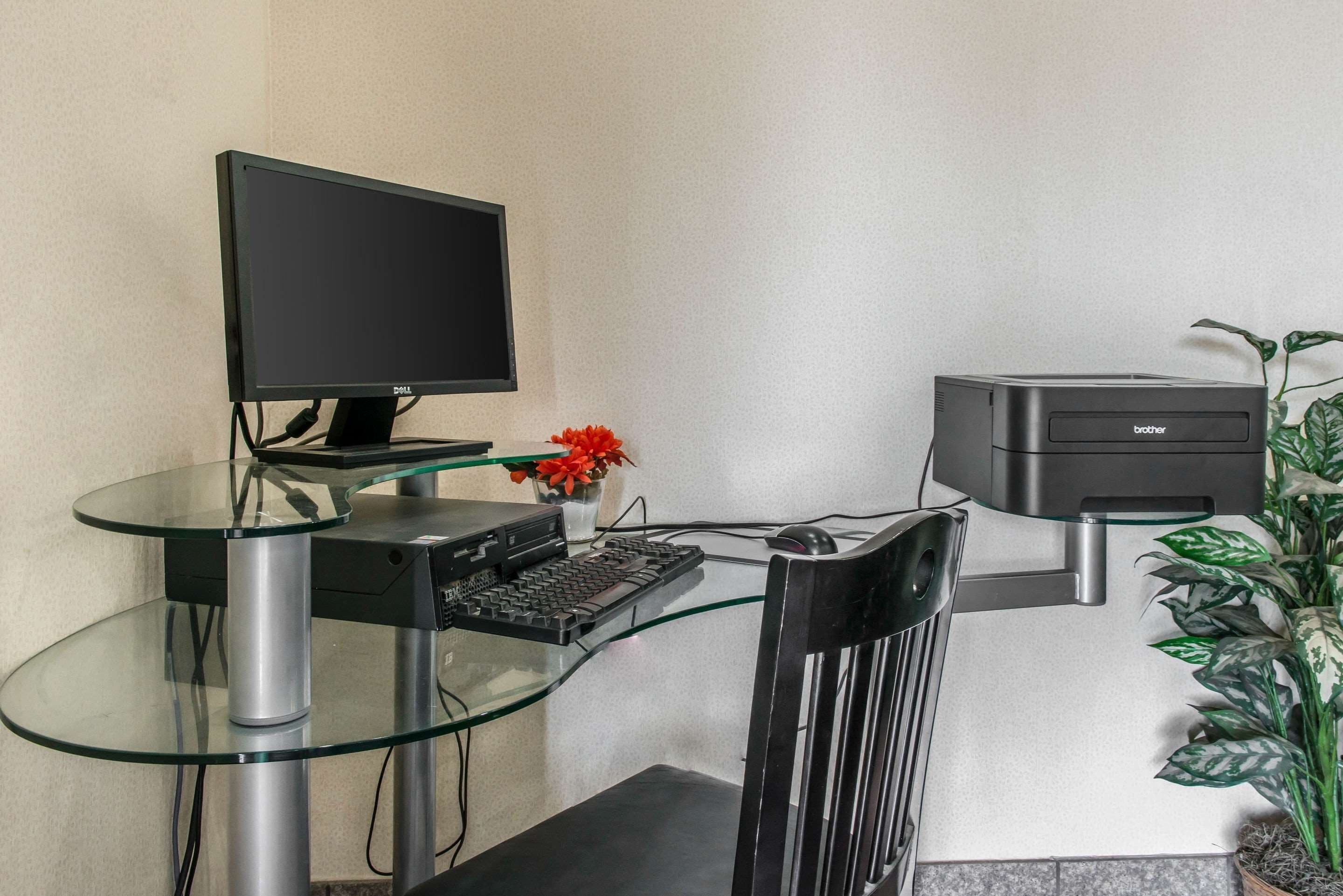 Un bureau moderne, équipé d’un écran d’ordinateur, d’un clavier et d’une imprimante.