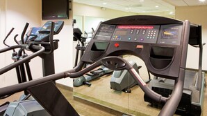Ein Fitnessstudio mit mehreren Laufbändern und Trainingsgeräten.