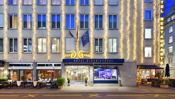 A hotel with a classic facade, multiple windows, and a sign indicating it is a restaurant. - Glärnischhof by Trinity (Zürich)