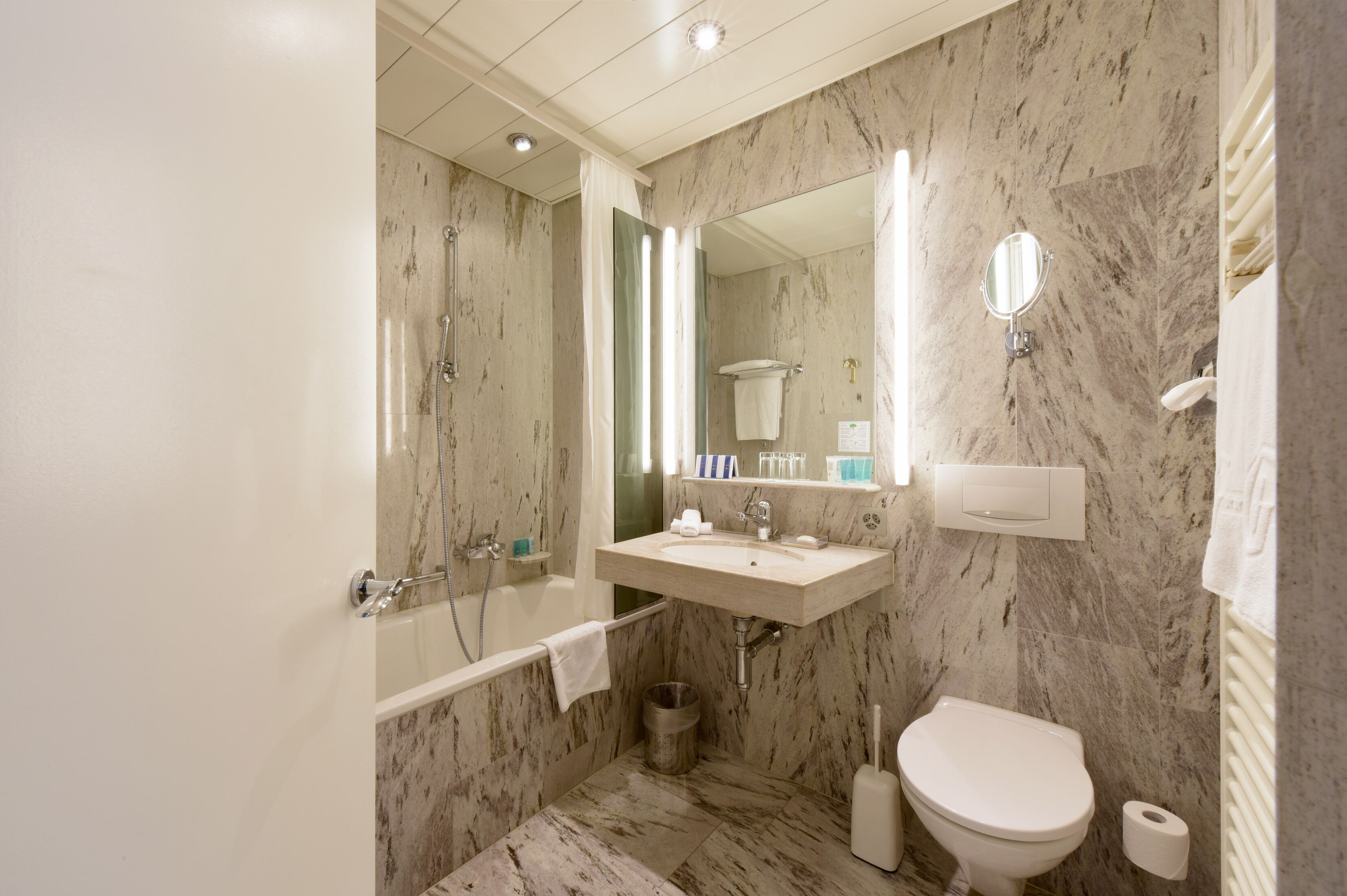 Ein Badezimmer mit Badewanne, Waschbecken, Toilette und Spiegel.