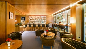 A bar area with leather chairs and a bar counter. - Glärnischhof by Trinity (Zürich)