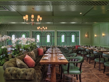 A bar area with green upholstered bar stools, a marble countertop, and a fireplace. at Inn At Rancho Santa Fe