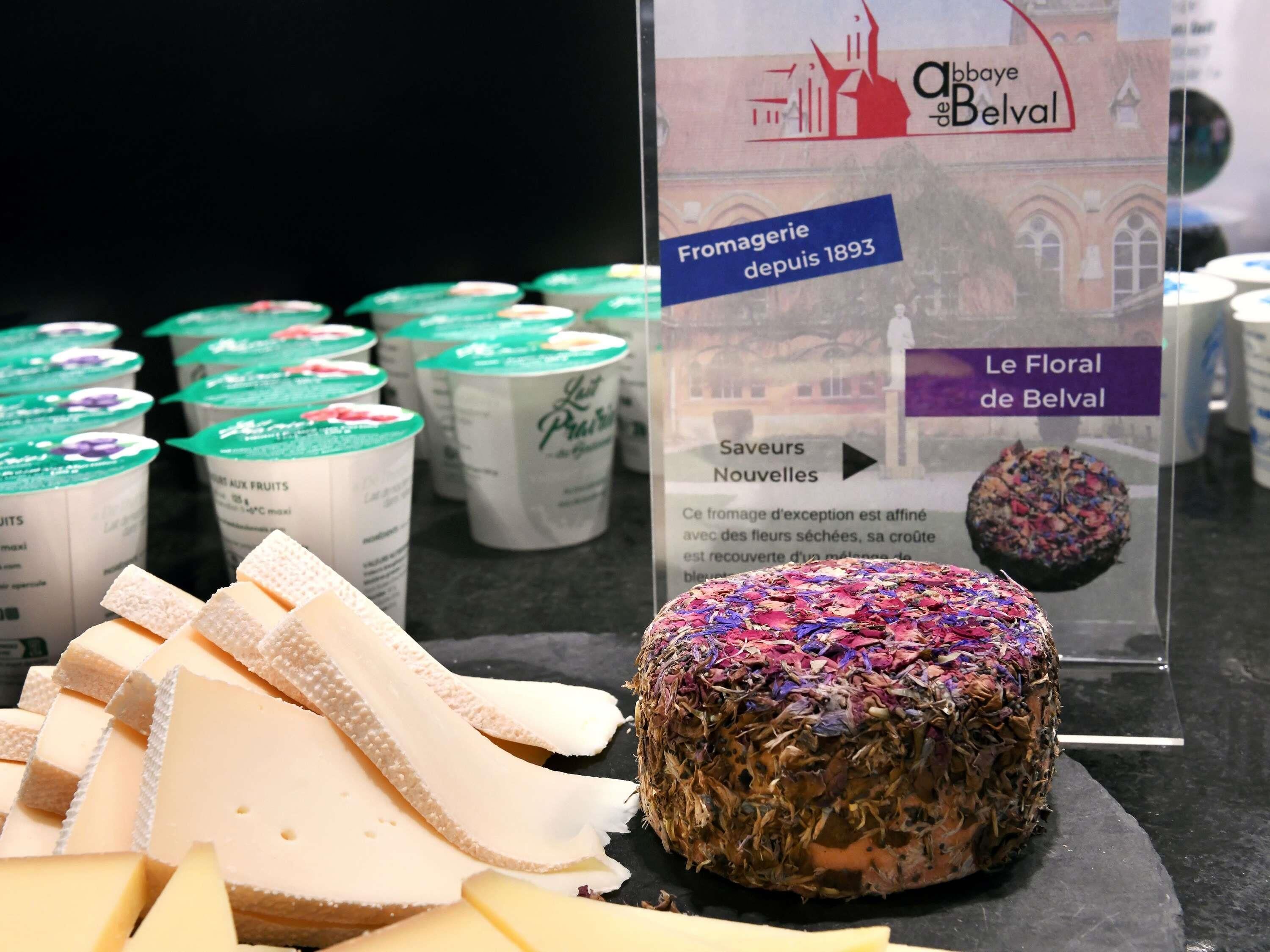 A cheese display with a sign indicating 'Fromagerie depuis 1893' and 'Le Floral de Belval'.