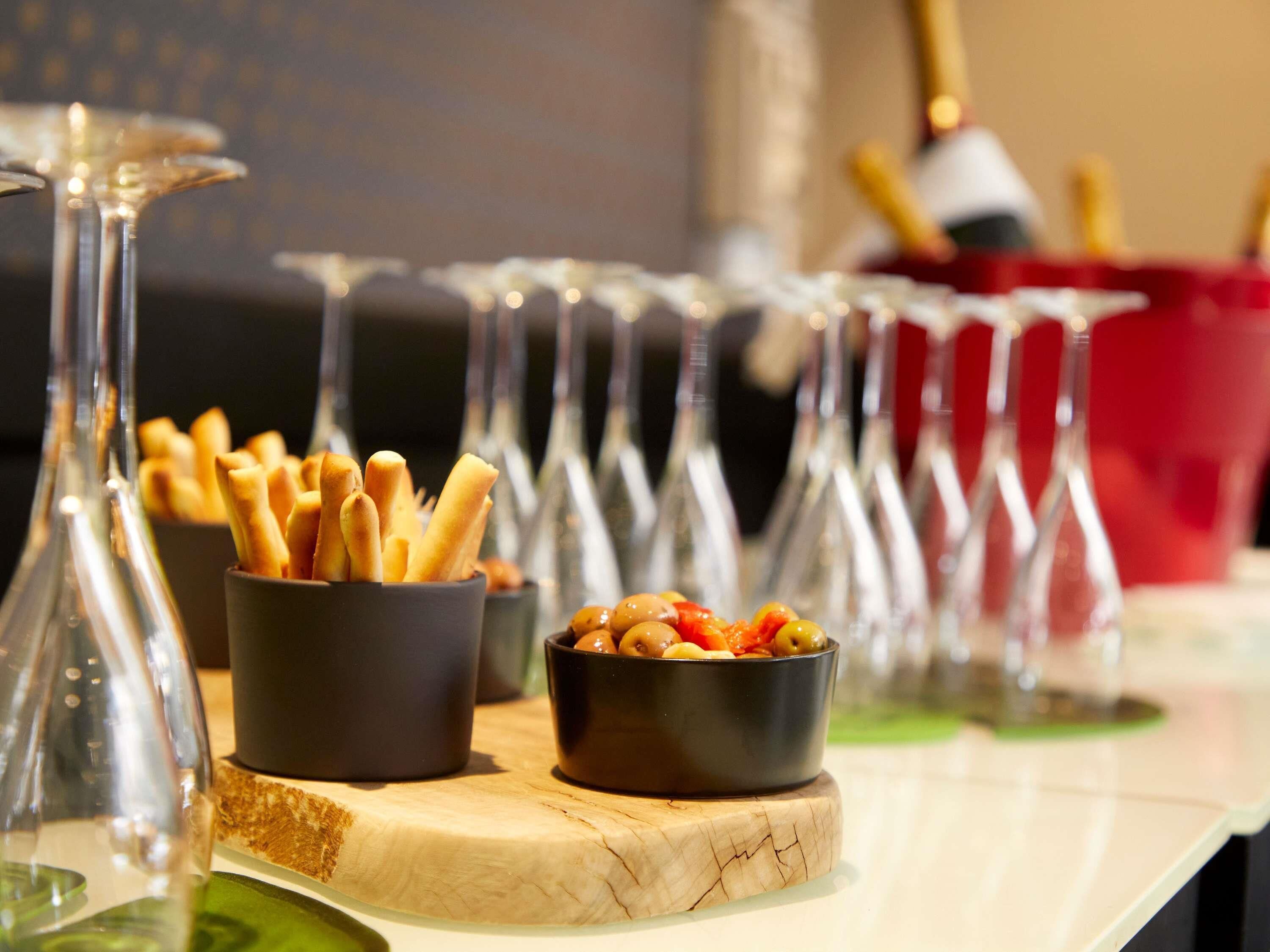 Una mesa con comida, vasos y una botella.
